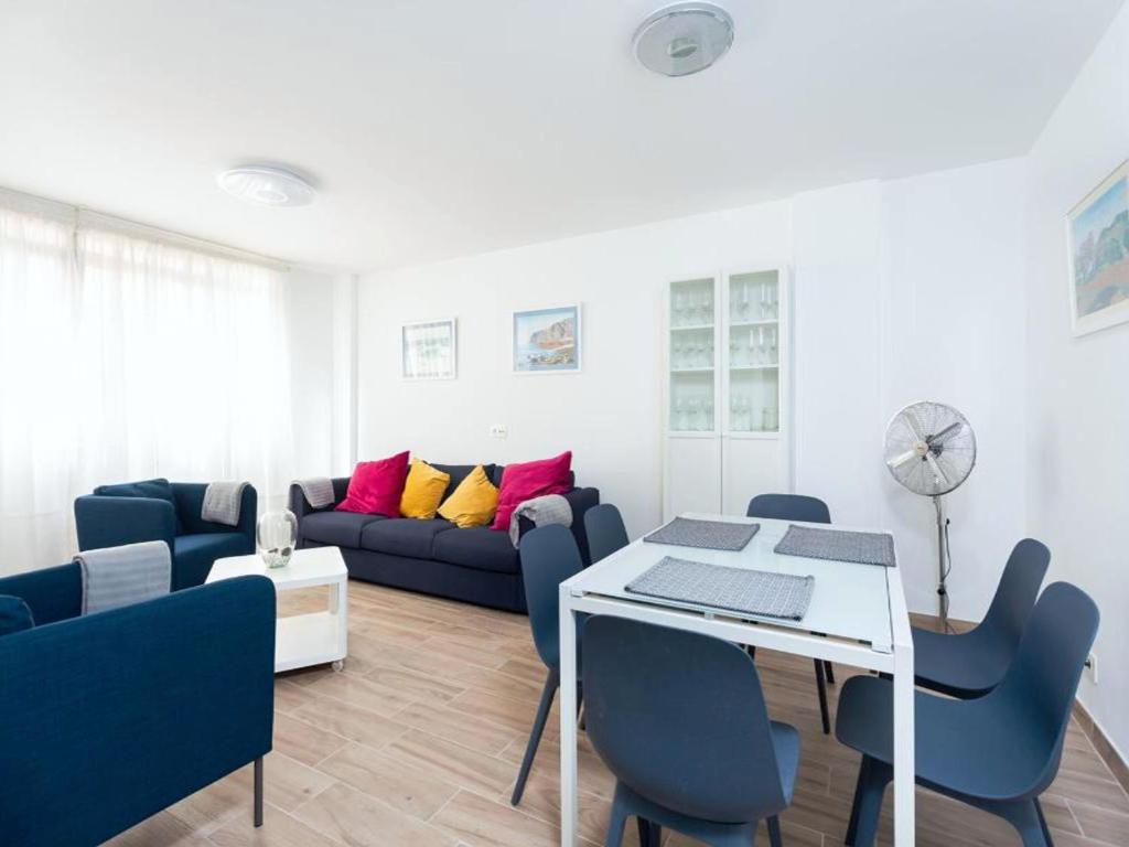 a living room with a couch and a table and chairs at Live Inglaterra Medano Beach in El M&eacute;dano