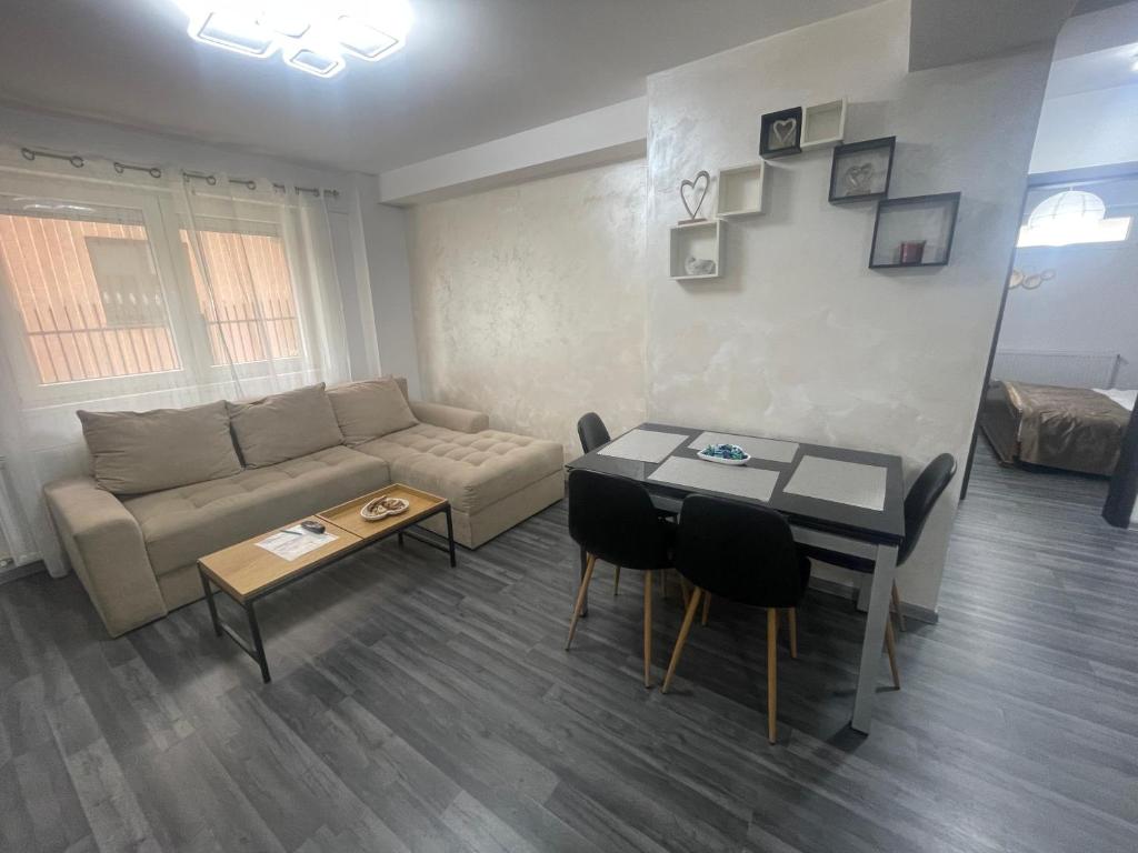 a living room with a couch and a table at ARKADIA APARTMENTs in Bucharest
