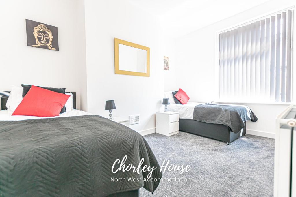 a bedroom with two beds and a window at Chorley Contractor Accommodation in Chorley