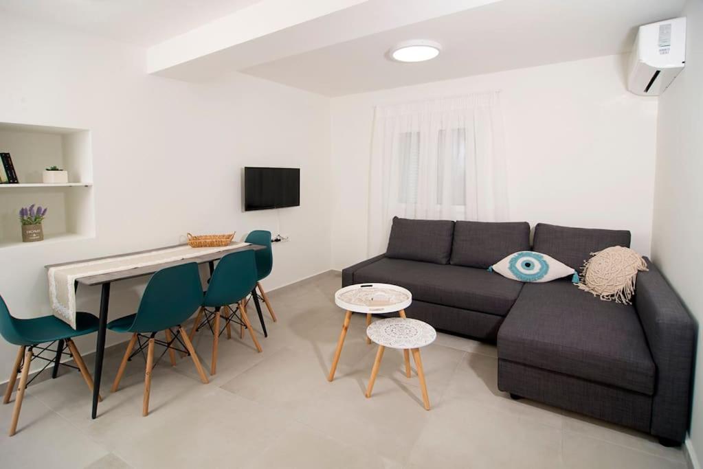 een woonkamer met een bank en een tafel en stoelen bij G&K House Garden in Messini
