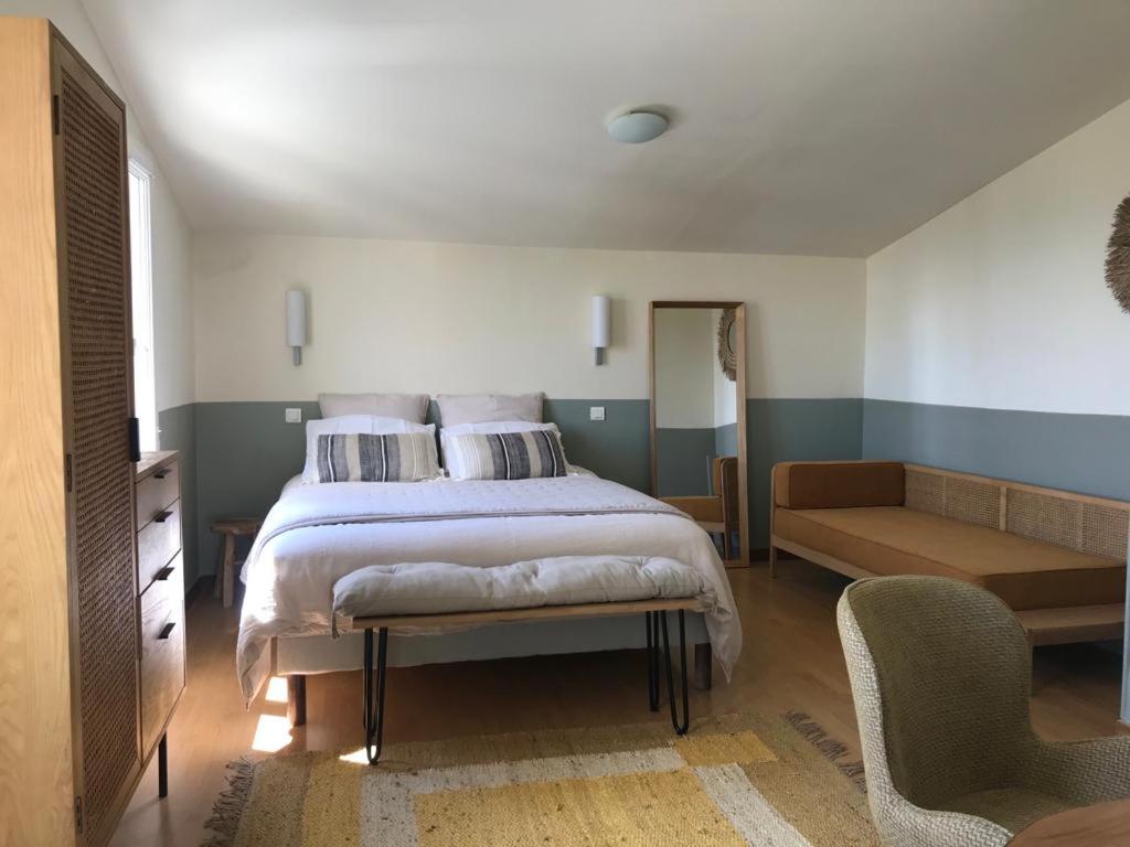 - une chambre avec un lit, un canapé et une chaise dans l'établissement L’OBSERVATOIRE, à Saint-Michel-lʼObservatoire