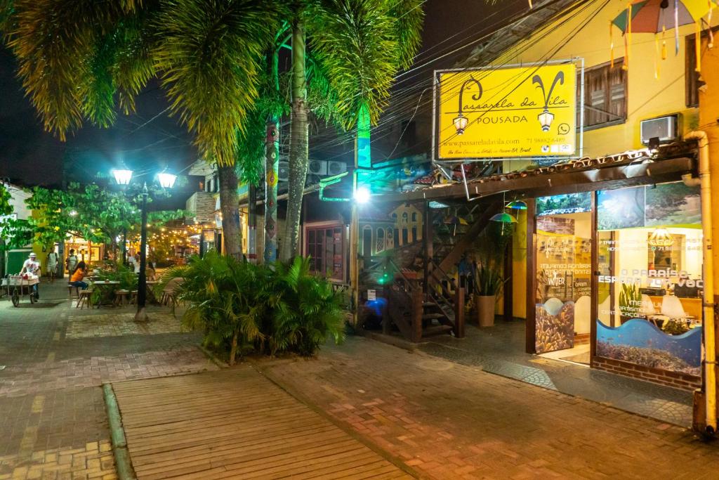 a city street at night with a store at PV Pousada Passarela da Vila in Itacaré