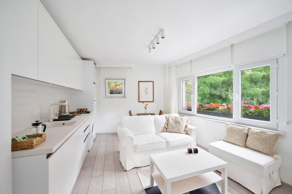 uma cozinha branca e sala de estar com um sofá e uma mesa em Modern Bright Cozy 1bed1bath Hidden Gem! #79 em Istambul