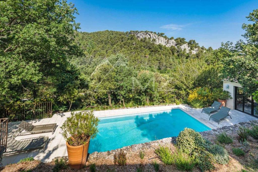 a swimming pool with a mountain in the background at Superbe Mas Authentique du Luberon Courroussouvo in Oppède