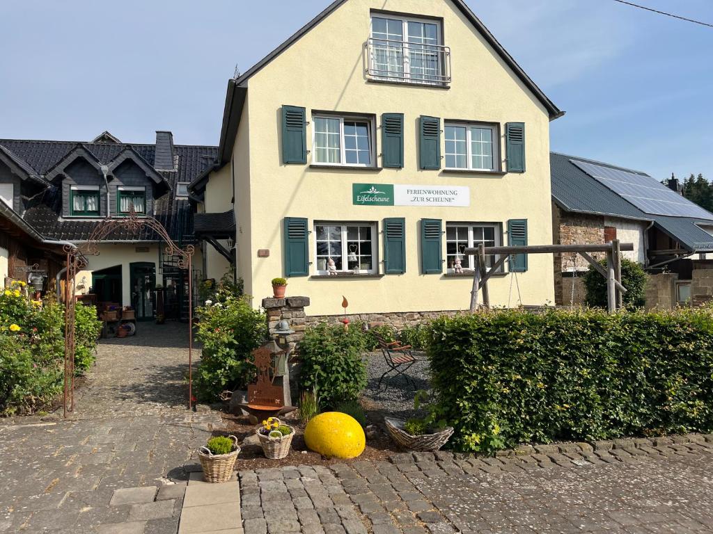 una casa con una bola amarilla delante de ella en Ferienwohnung Zur Scheune, en Boos