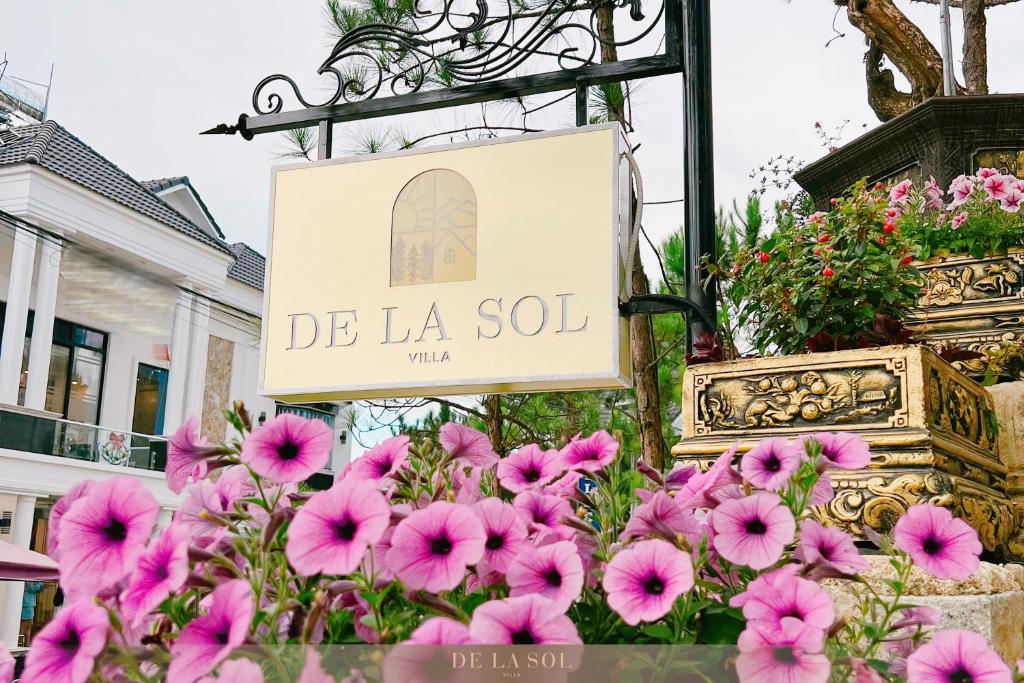 a sign for de la sol with pink flowers at De La Sol Villa Dalat in Da Lat