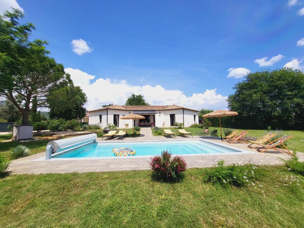 una piscina con sillas y una casa en Villa 5 étoiles piscine chauffée 8 pers 'Casa Sista' by Casa FAMILIA Ardèche, en Sampzon