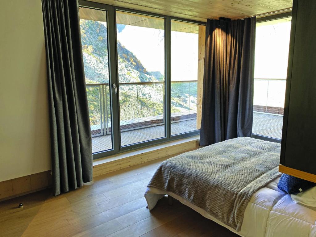 ein Schlafzimmer mit einem Bett und einem großen Fenster in der Unterkunft Lagrange Vacances L’Écrin du Badet in Aragnouet