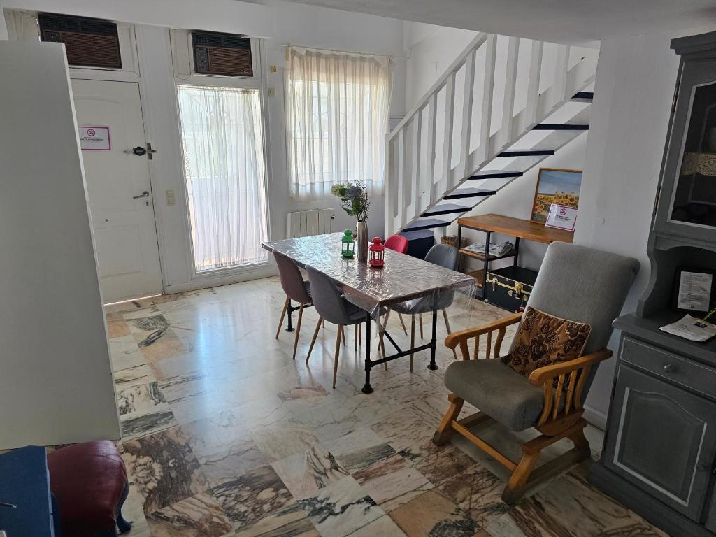 een woonkamer met een tafel en stoelen en een trap bij Apartamento Las Brisas II in Valencina de la Concepción