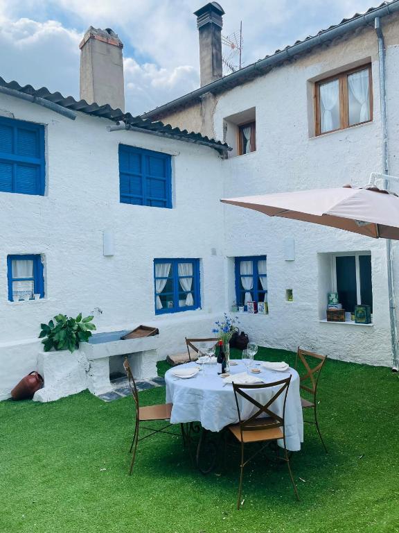 a table and chairs in front of a white building at Casa Fulanita in Cabezuela