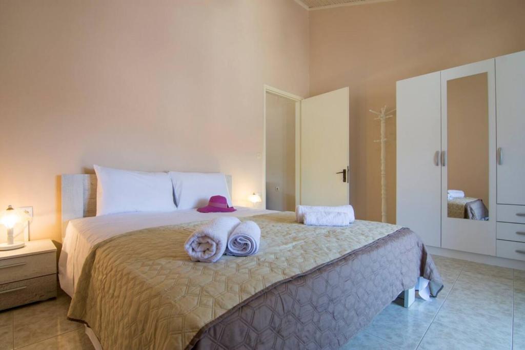 um quarto com uma cama grande e toalhas em Paxos In Square (Apartment Amfitriti) em Gaios
