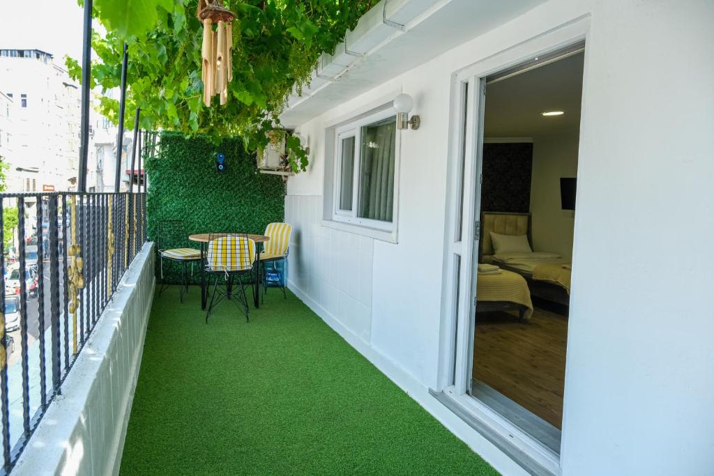 a balcony with green flooring and a table and chairs at Taksim Neo Pera Suites in Istanbul