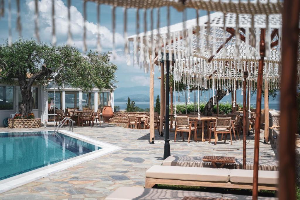 un resort con piscina, tavoli e ombrelloni di Panorama Hideaway a Dassia
