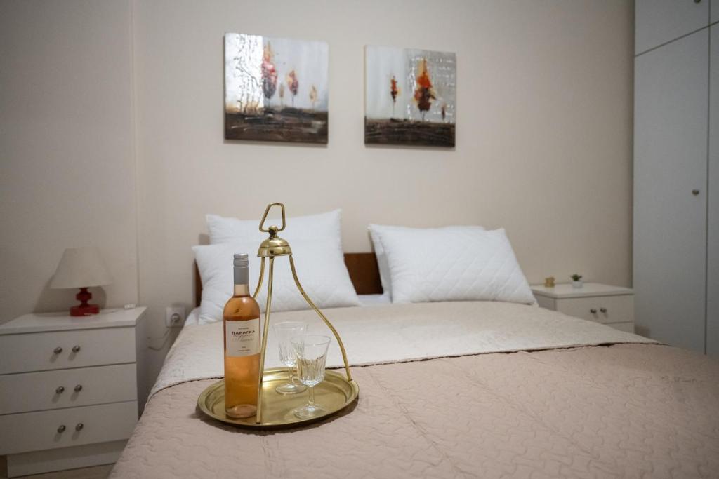 a bottle of wine and two glasses on a bed at KLEIO in Nea Moudania