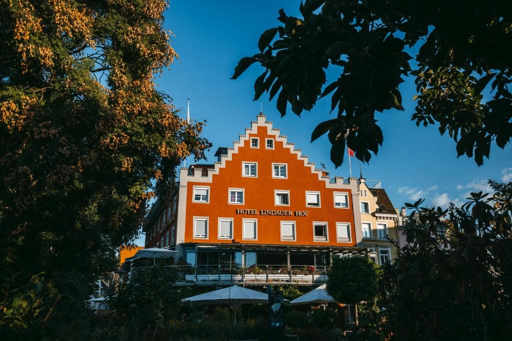 ein großes orangenes Gebäude mit einem Schild drauf in der Unterkunft Hotel Lindauer Hof in Lindau