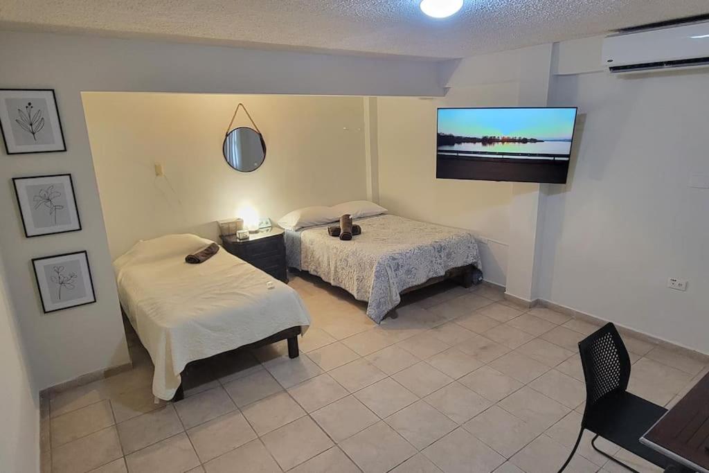 1 dormitorio con 2 camas y TV de pantalla plana en Departamento ( j ) Comodo centrico Tv Ac wifi cocina parking, en Ciudad Valles