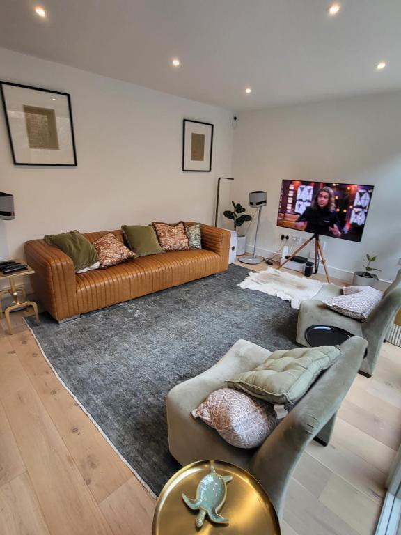 a living room with a couch and a flat screen tv at Amazing 5 Stars Home in London