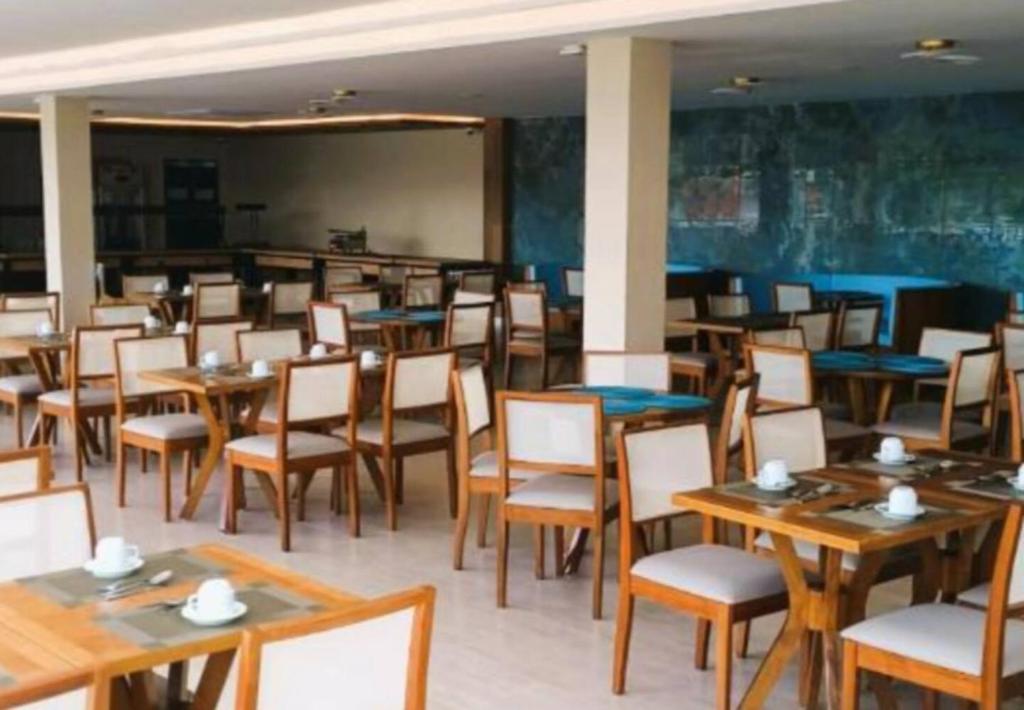 a dining room with wooden tables and chairs at Suite - Aqualand Suites in Salinópolis