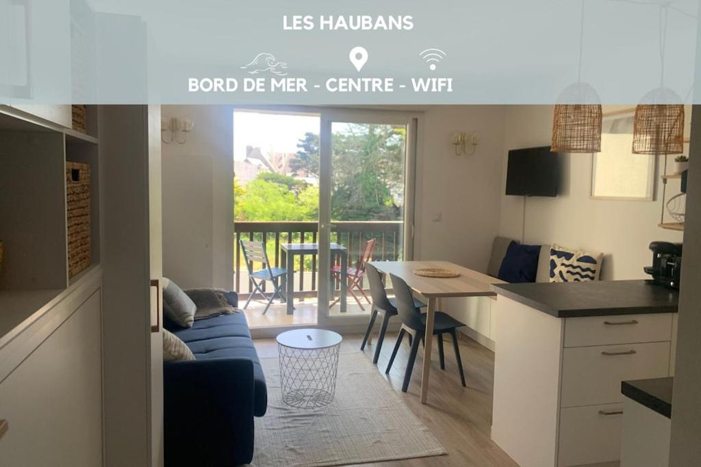 une cuisine et un salon avec un canapé et une table dans l'établissement Les Haubans * Moderne * Calme * Wifi, à La Trinité-sur-Mer