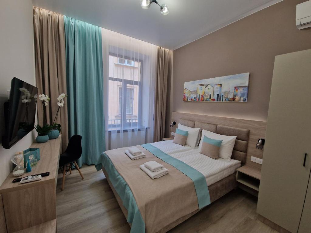 Schlafzimmer mit einem Bett, einem Schreibtisch und einem Fenster in der Unterkunft DeMar Apart Doroshenka in Lwiw