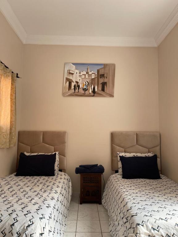 1 dormitorio con 2 camas y una foto en la pared en Riad Nour Travel-Les Riads Nour Resorts en Marrakech