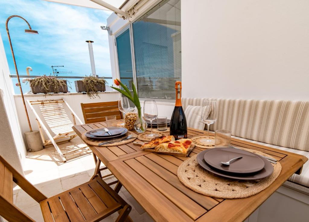 a table with a bottle of wine and a plate of food at Dimora del Vico - Exclusive Terrace with View in Cisternino