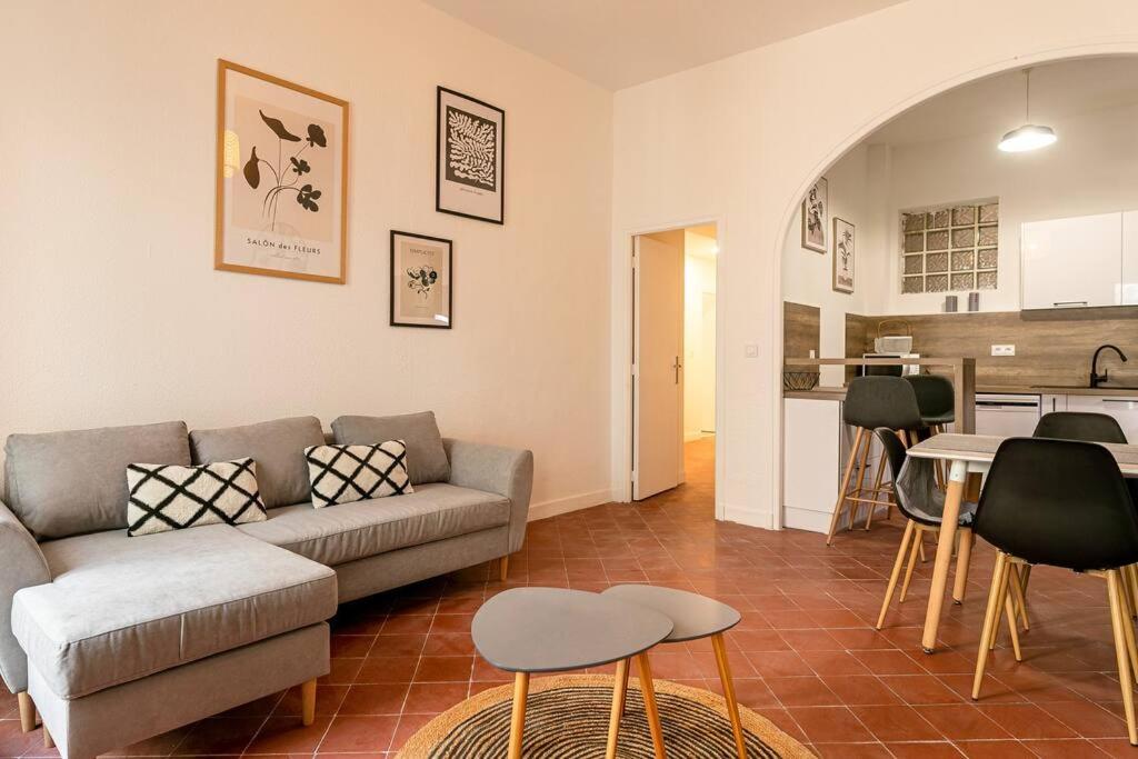 a living room with a couch and a kitchen at Lumineux T5 - Climatisation in Perpignan