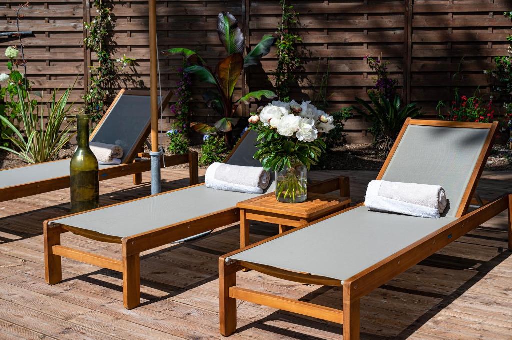 a row of tables with chairs and a vase of flowers at Lou Cagnard in Saint-Tropez