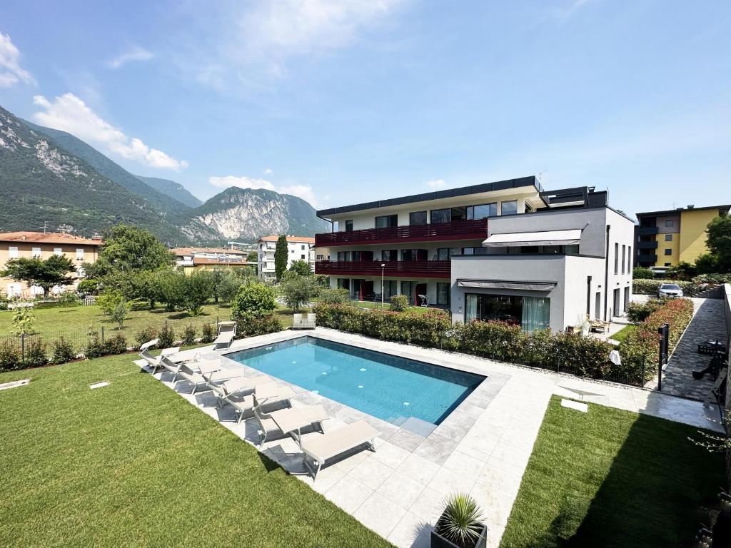 a swimming pool with lounge chairs and a building at Residence Zangirolami - Luxury Garden and Balcony Apartments in Riva del Garda