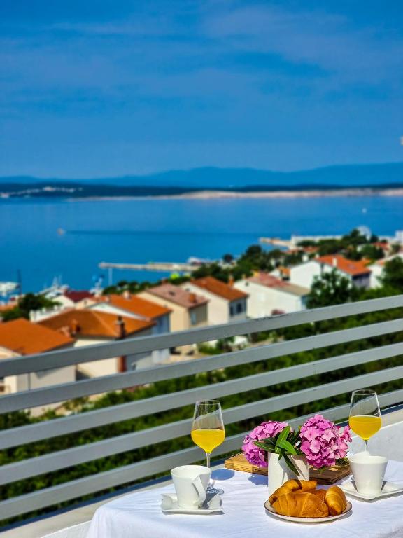 a table with two glasses of wine and flowers at Adria Mare in Crikvenica