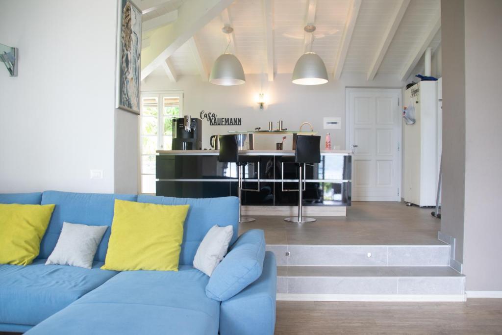 um sofá azul com almofadas amarelas numa sala de estar em Casa Isola Superiore - WelcHome em San Bartolomeo