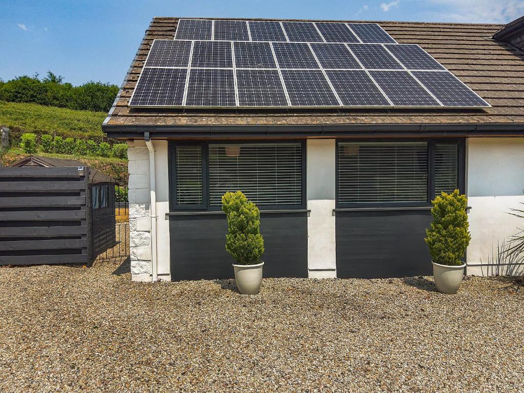 een huis met zonnepanelen op het dak bij Petersfield Farm Bungalow Annexe in Dobwalls