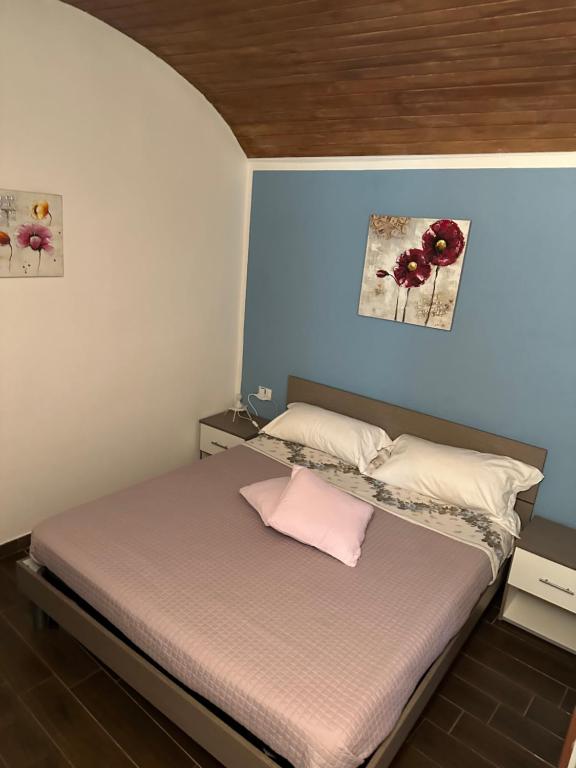 Dormitorio pequeño con cama con almohada rosa en Le Antiche Mura, en Sassari
