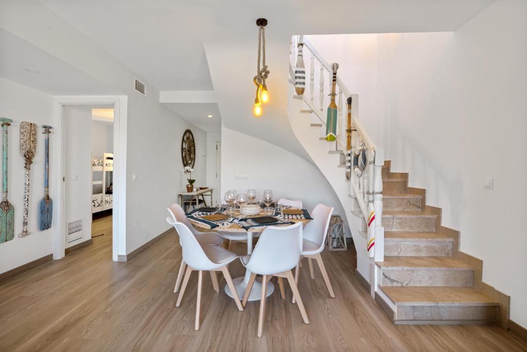 a dining room with a table and white chairs at Blue Greenwich Port in Altea