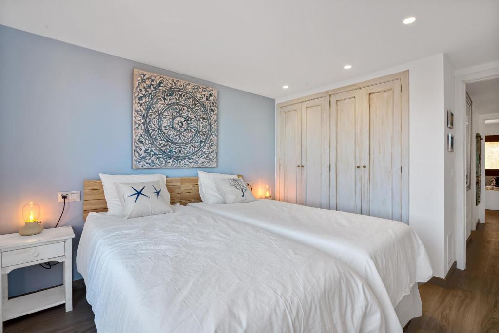 a white bedroom with a large bed with white sheets at Blue Greenwich Port in Altea