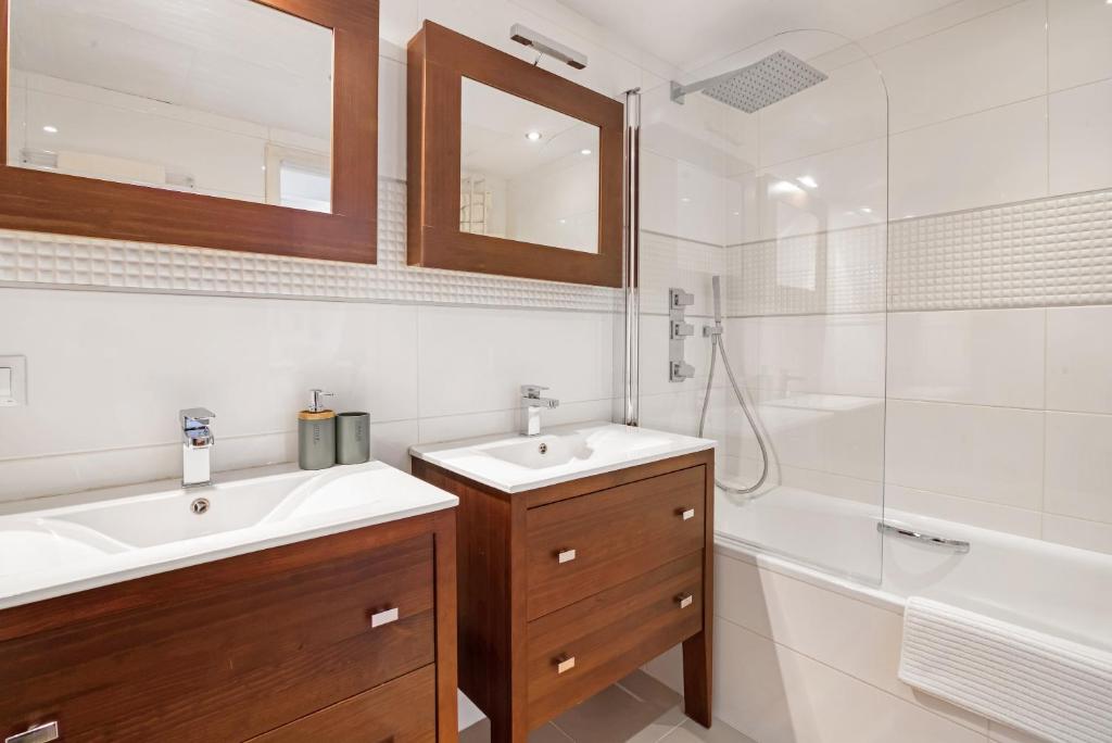 a bathroom with a sink and a tub and a mirror at Blue Greenwich Port in Altea