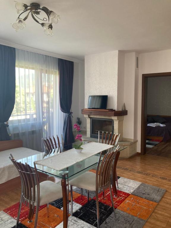 uma sala de jantar com mesa e cadeiras e uma sala de estar em GD Apartament em Bansko