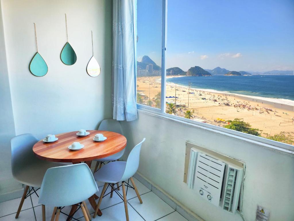 una mesa y sillas en una habitación con vistas a la playa en Apto Vista Completa da Praia de Copacabana TC803, en Río de Janeiro