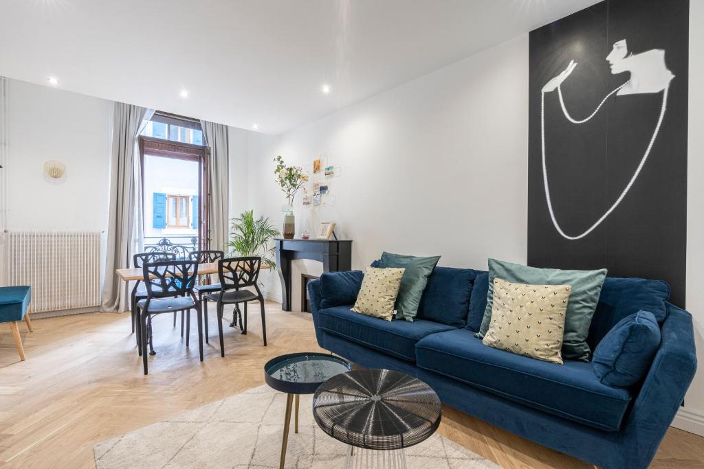 a living room with a blue couch and a table at L'Exception, sérénité et confort, Evian centre in Évian-les-Bains