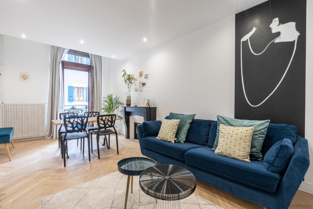 ein Wohnzimmer mit einem blauen Sofa und einem Tisch in der Unterkunft L'Exception, sérénité et confort, Evian centre in Évian-les-Bains