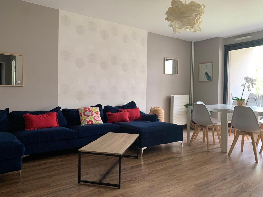 - un salon avec un canapé bleu et une table dans l'établissement L'Escale - appartement spacieux au calme, à Brest
