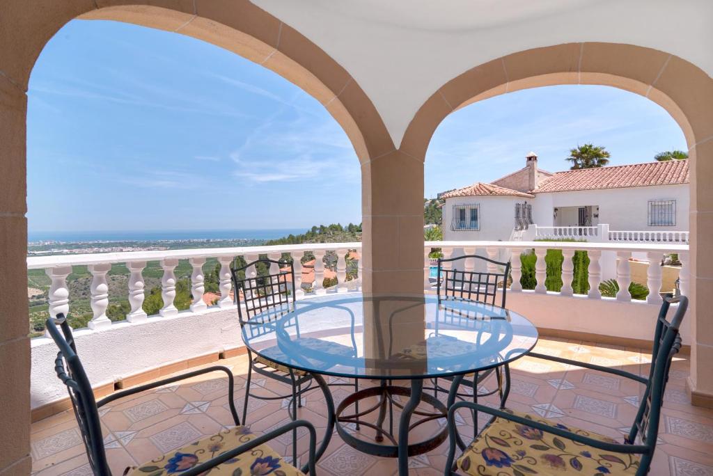 a table and chairs on a balcony with a view of the ocean at Tossal Gros in La Font D´En Carròs