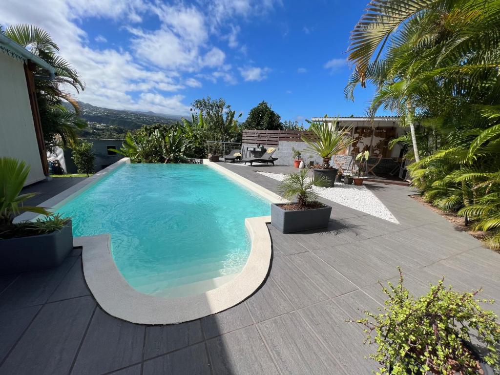 uma piscina num quintal com palmeiras em Villa Ti MoOn, Entre deux, Piscine em Entre-Deux