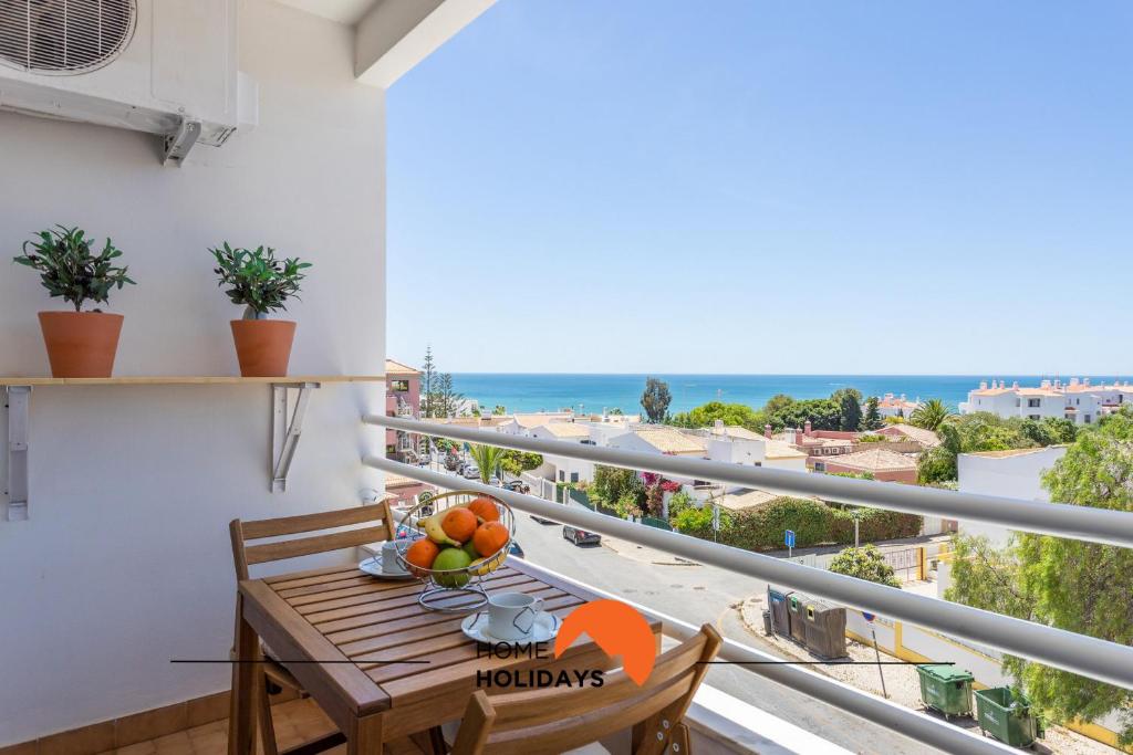 een balkon met een tafel en uitzicht op de oceaan bij #005 Foxy B by Home Holidays in Albufeira
