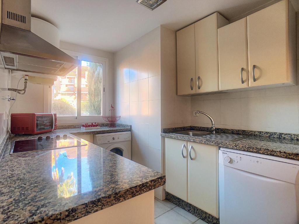 kuchnia z białymi szafkami i granitowymi blatami w obiekcie 2231 - Amazing 3 bedrooms with 3 sunny terraces w mieście Casares