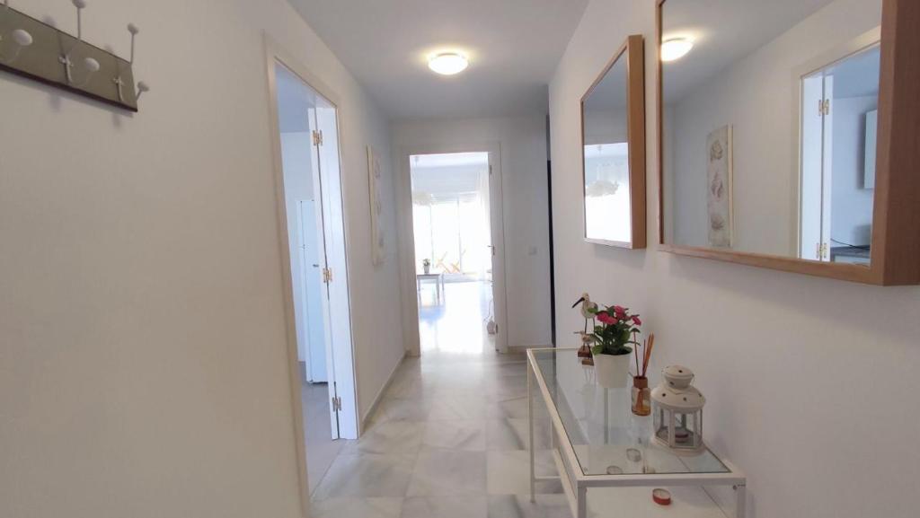 przedpokój ze szklanym stołem i lustrem w obiekcie TurAlmeria - Mirador Del Cabo1 - Apartamento con 2 dormitorios, 2 baños, piscina y plaza de garaje con vistas al mar en Retamar - Almería w mieście Retamar