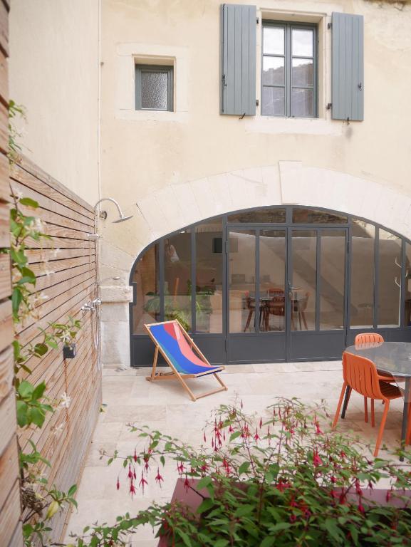 un patio avec des chaises et une table en face d'un bâtiment dans l'établissement Le Clos des Confidences, à Grignan