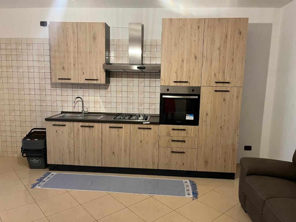 a kitchen with wooden cabinets and a microwave at Residenza Martellotta in Bari