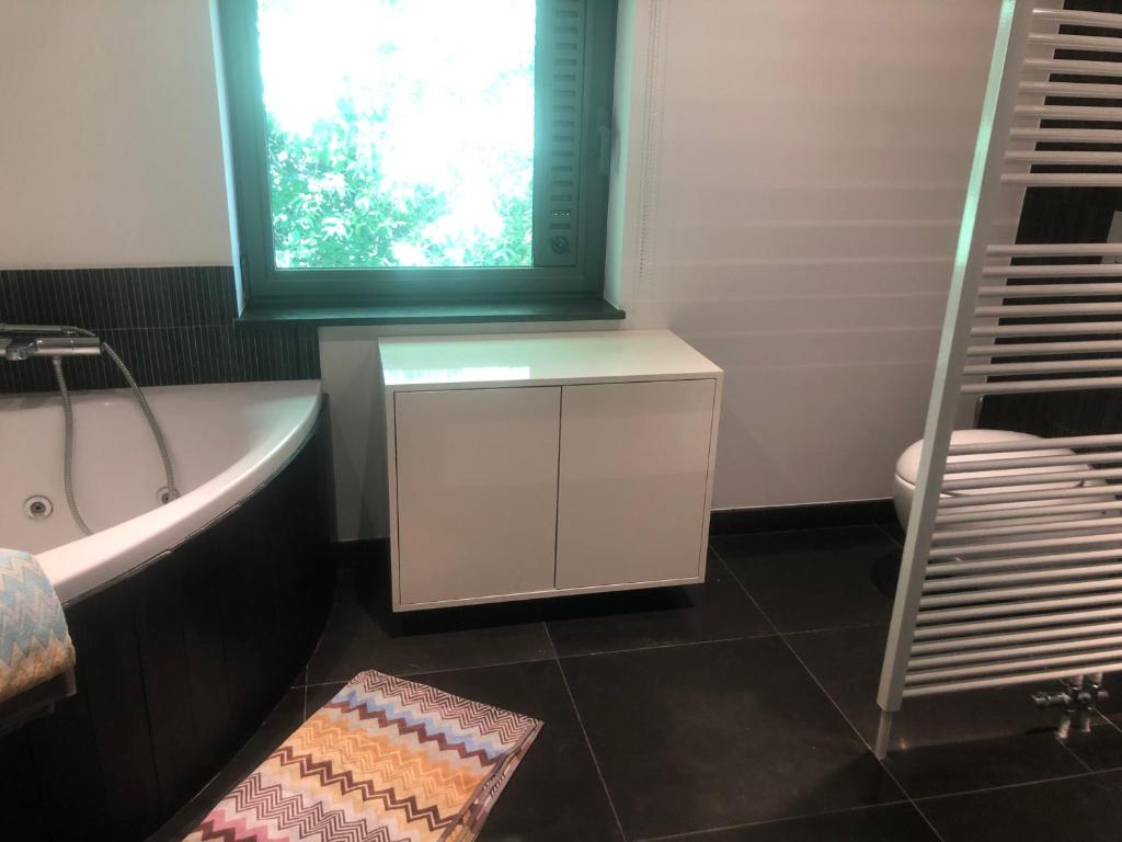 a bathroom with a bath tub and a window at landelijke villa met zwembad en gezellige openhaard in Zemst