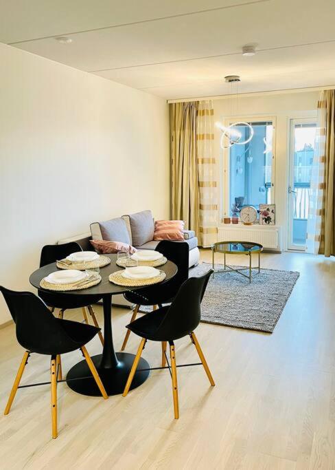 a living room with a table and chairs and a couch at Modern family apartment next to metro easy access to Helsinki in Espoo